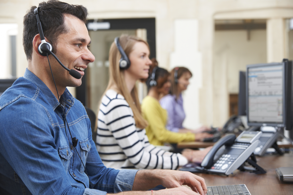 call center agents working on computer with head sets on