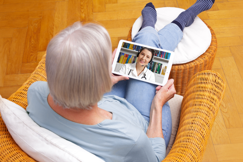 Baby boomer woman talks to her doctor using telehealth - 2024 insurance industry trends